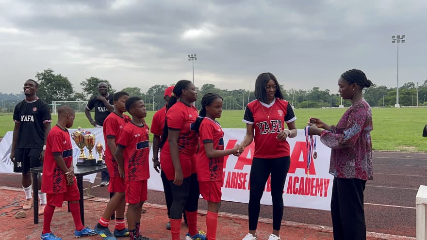 Parent volunteer presenting medals to young YAFA players at a tournament