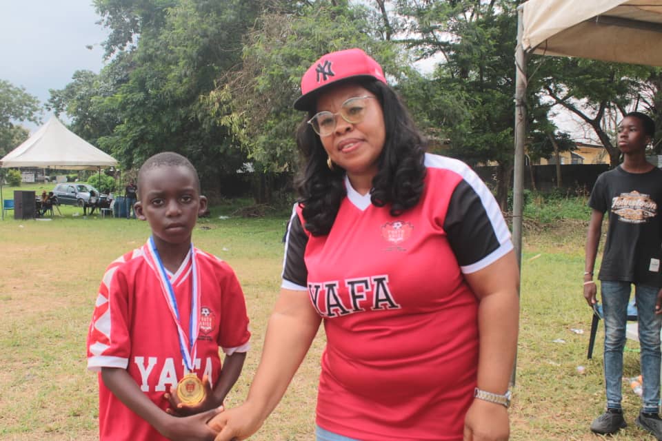 A YAFA Mum with a young player proudly holding his medal
